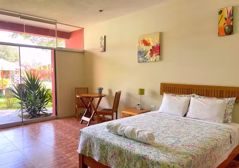 Habitación Matrimonial en primer piso de Huertalejandro Cieneguilla equipada con cama Queen y vista hacia las áreas verdes