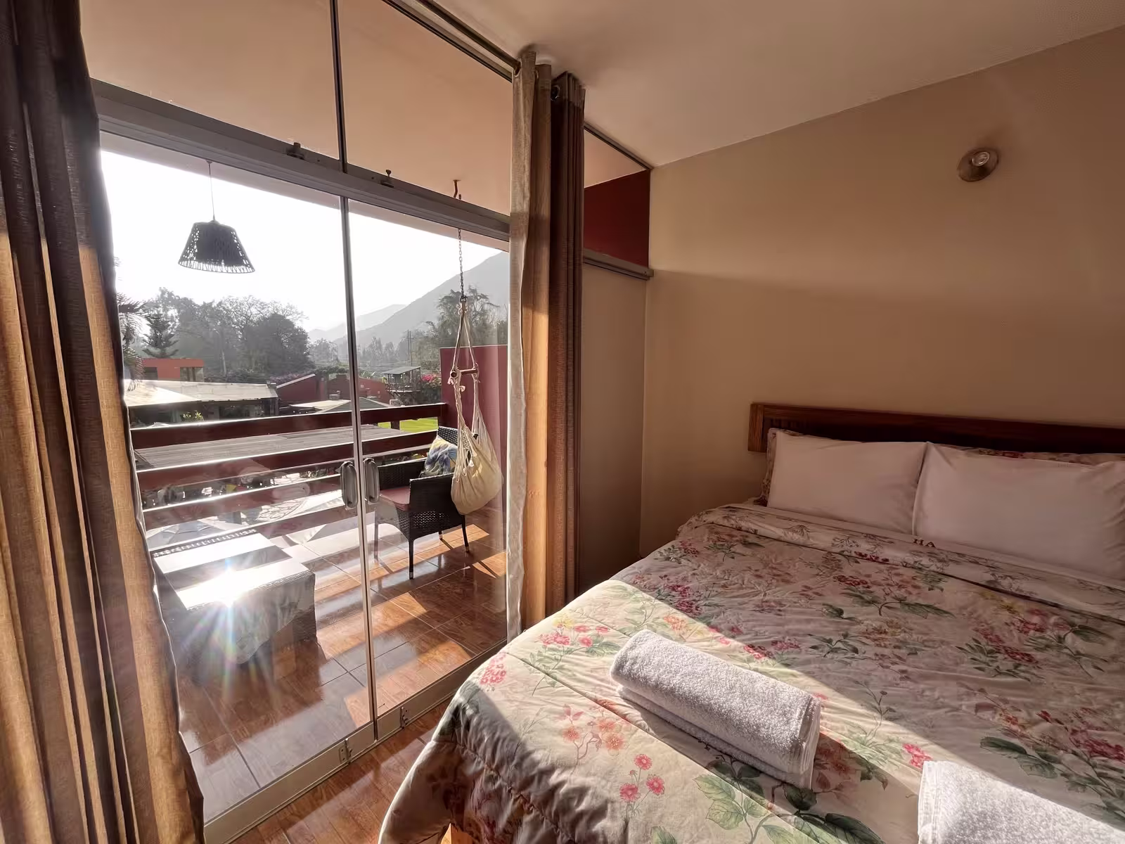 Habitación de Huertalejandro en Cieneguilla con cama matrimonial, terraza privada con hamaca blanca y vista a las montañas y áreas verdes